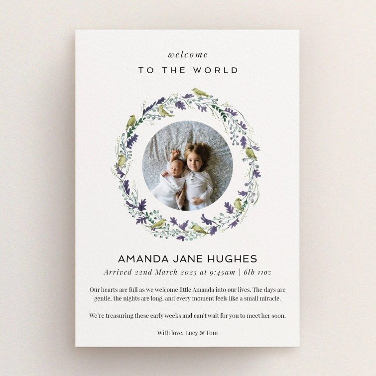 Floral wreath birth announcement card with two photos of siblings.