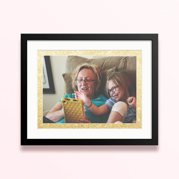 Framed and mounted photo print with two people on a couch.