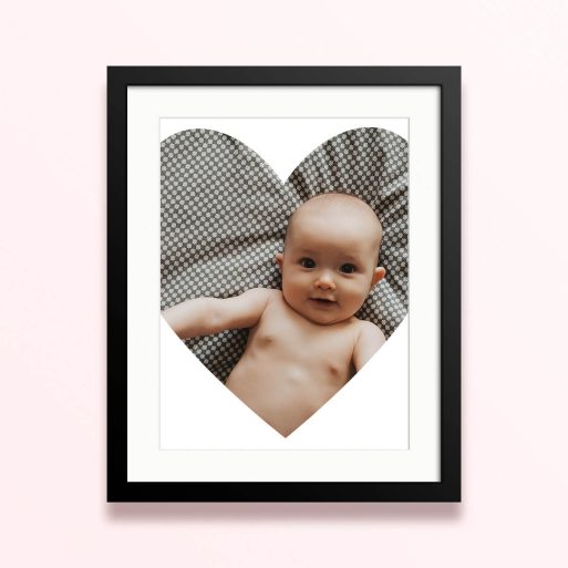 Framed and mounted photo print with one photo of a baby in a heart-shaped cutout design.