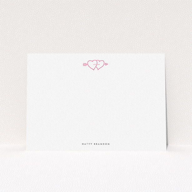 A ladies personalised note card design titled "Arrow through the hearts". It is an A5 card in a landscape orientation. "Arrow through the hearts" is available as a flat card, with tones of white and pink.