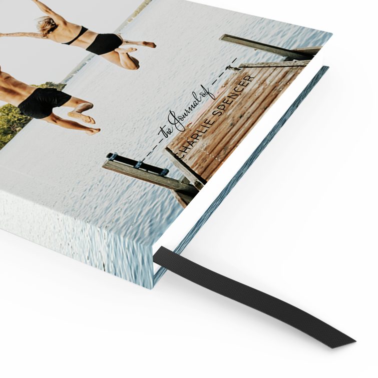 Portrait orientation notebook design with one photo of a couple jumping into a lake, showcasing a vibrant outdoor scene.