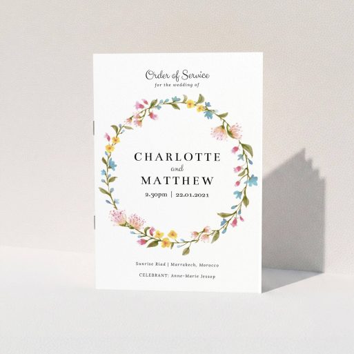 A multipage wedding order of service template titled "Spring Wedding Wreath". It is an A5 booklet in a portrait orientation. "Spring Wedding Wreath" is available as a folded booklet booklet, with mainly pink colouring.