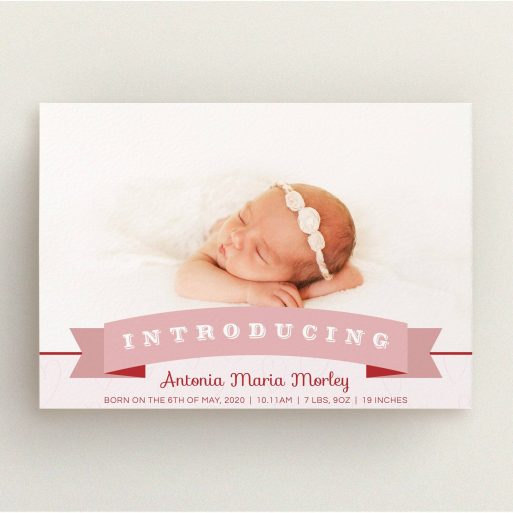 A new baby announcement card named "Big Banner". It is an A5 card in a landscape orientation. It is a photographic new baby announcement card with room for 1 photo. "Big Banner" is available as a flat card, with tones of pink, red and white.