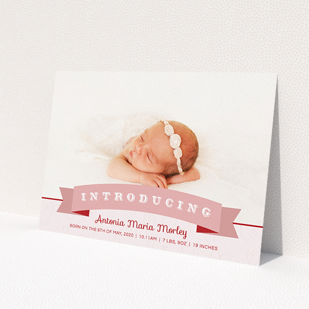 A new baby announcement card named 'Big Banner'. It is an A5 card in a landscape orientation. It is a photographic new baby announcement card with room for 1 photo. 'Big Banner' is available as a flat card, with tones of pink, red and white.