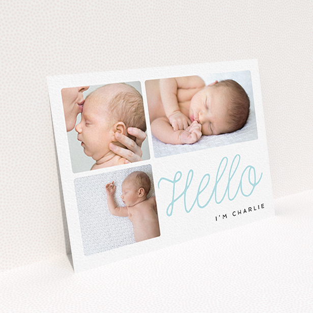 A new baby announcement card template titled "Hello Cursive". It is an A6 card in a landscape orientation. It is a photographic new baby announcement card with room for 3 photos. "Hello Cursive" is available as a flat card, with tones of white and blue.