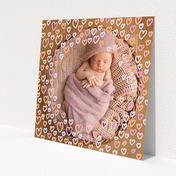 A new baby announcement card design named 'Pink Hearts'. It is a square (148mm x 148mm) card in a square orientation. It is a photographic new baby announcement card with room for 1 photo. 'Pink Hearts' is available as a flat card, with mainly light pink colouring.