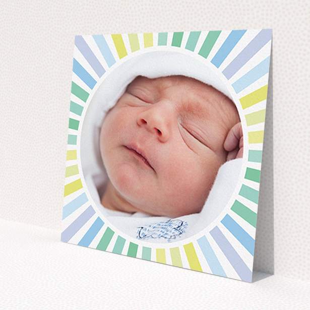 A new baby announcement card design named 'Sun Centre'. It is a square (148mm x 148mm) card in a square orientation. It is a photographic new baby announcement card with room for 1 photo. 'Sun Centre' is available as a flat card, with mainly light blue colouring.