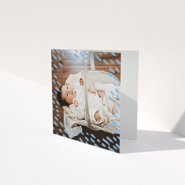 A new baby thank you card named "Blue Daubs". It is a square (148mm x 148mm) card in a square orientation. It is a photographic new baby thank you card with room for 1 photo. "Blue Daubs" is available as a folded card, with mainly blue colouring.