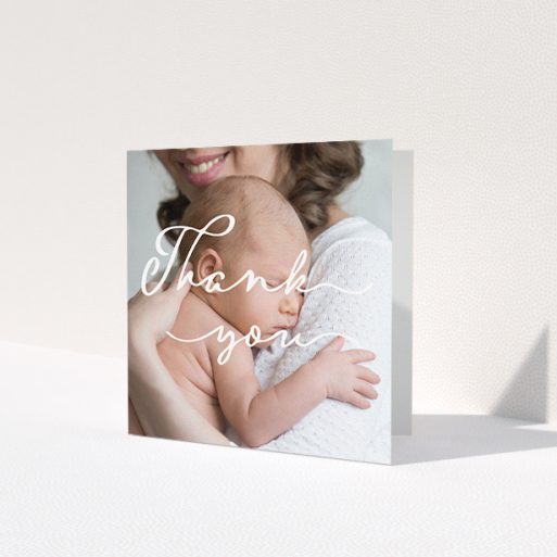A new baby thank you card design named 'White Thank You'. It is a square (148mm x 148mm) card in a square orientation. It is a photographic new baby thank you card with room for 1 photo. 'White Thank You' is available as a folded card, with mainly white colouring.