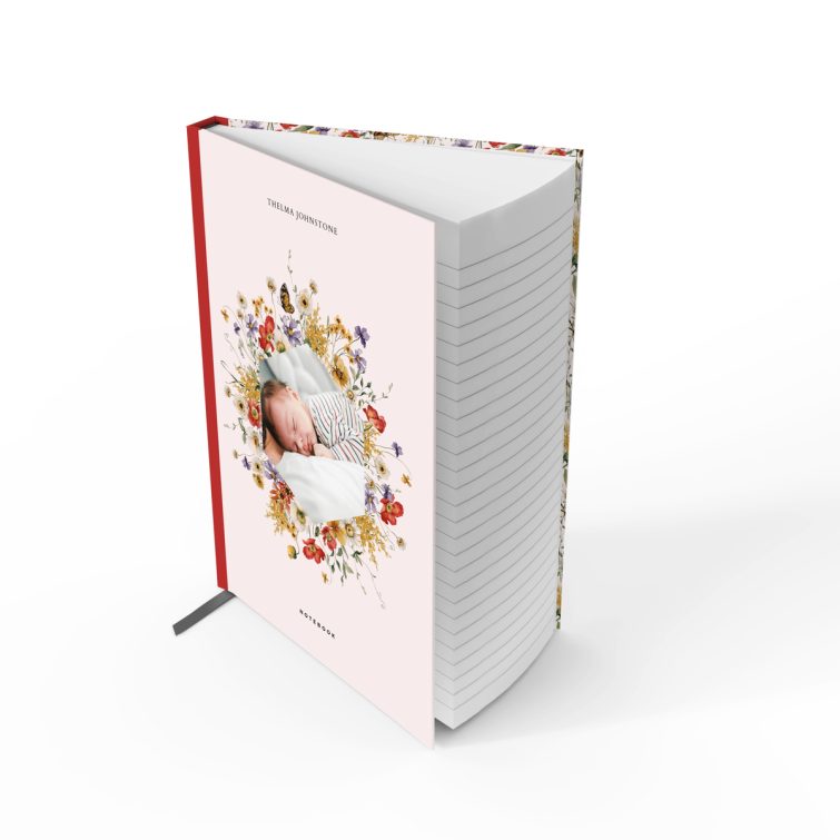 Floral patterned notebook cover design with one photo of a baby surrounded by flowers.