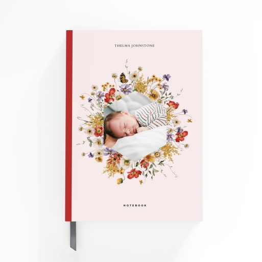 Floral patterned notebook cover design with one photo of a baby surrounded by flowers.