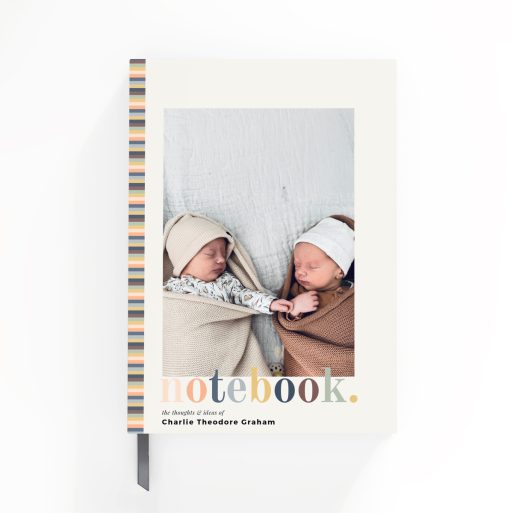 Portrait notebook design with striped spine and a photo on the front cover featuring two infants.