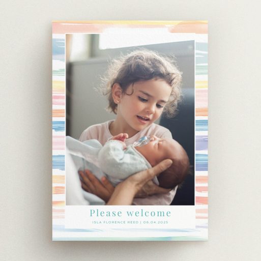 Colourful birth announcement card featuring a photo of a child holding a baby.