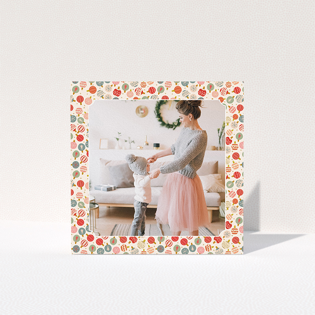 A personalised christmas card called "Bauble Photo". It is a square (148mm x 148mm) card in a square orientation. It is a photographic personalised christmas card with room for 1 photo. "Bauble Photo" is available as a folded card, with tones of pink, red and light blue.