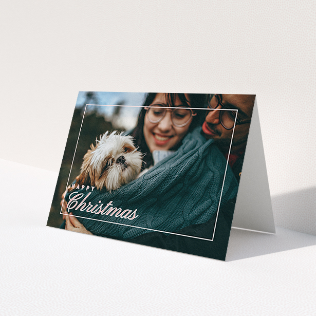 A personalised christmas card named 'Border Overlay'. It is an A6 card in a landscape orientation. It is a photographic personalised christmas card with room for 1 photo. 'Border Overlay' is available as a folded card, with mainly light pink colouring.