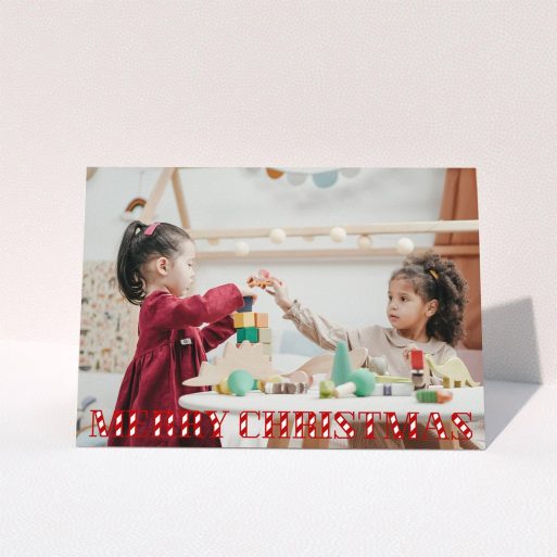 A personalised christmas card design titled "Candy Cane". It is an A6 card in a landscape orientation. It is a photographic personalised christmas card with room for 1 photo. "Candy Cane" is available as a folded card, with mainly red colouring.