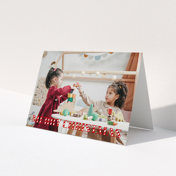 A personalised christmas card design titled "Candy Cane". It is an A6 card in a landscape orientation. It is a photographic personalised christmas card with room for 1 photo. "Candy Cane" is available as a folded card, with mainly red colouring.