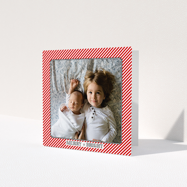 A personalised christmas card called 'Deco Candy-cane'. It is a square (148mm x 148mm) card in a square orientation. It is a photographic personalised christmas card with room for 1 photo. 'Deco Candy-cane' is available as a folded card, with tones of red and white.