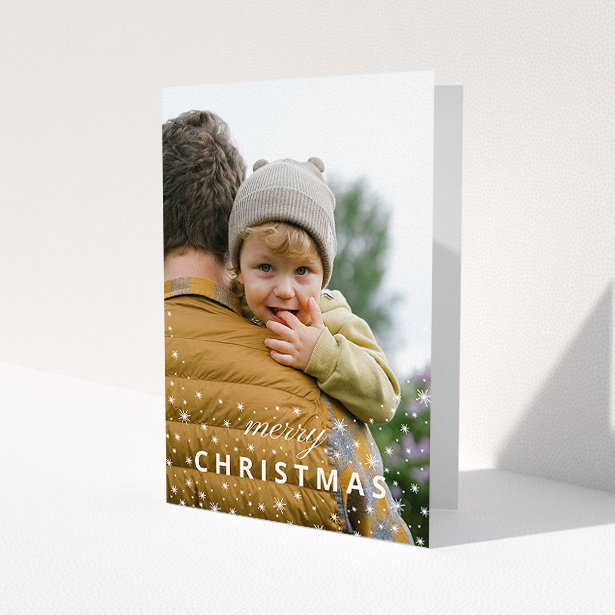 A personalised christmas card called 'Falling Snow Photo'. It is an A5 card in a portrait orientation. It is a photographic personalised christmas card with room for 1 photo. 'Falling Snow Photo' is available as a folded card, with mainly white colouring.