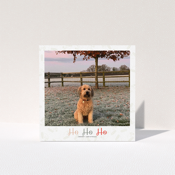 A personalised christmas card design called "Ho Ho etc.". It is a square (148mm x 148mm) card in a square orientation. It is a photographic personalised christmas card with room for 1 photo. "Ho Ho etc." is available as a folded card, with tones of cream, red and pink.