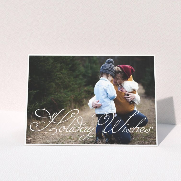 A personalised christmas card called "Holiday Wishes". It is an A5 card in a landscape orientation. It is a photographic personalised christmas card with room for 1 photo. "Holiday Wishes" is available as a folded card, with mainly white colouring.