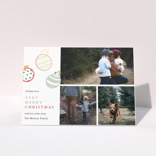 A personalised christmas card named "Pastel Baubles". It is an A5 card in a landscape orientation. It is a photographic personalised christmas card with room for 3 photos. "Pastel Baubles" is available as a folded card, with tones of white and green.