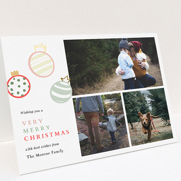 A personalised christmas card named "Pastel Baubles". It is an A5 card in a landscape orientation. It is a photographic personalised christmas card with room for 3 photos. "Pastel Baubles" is available as a folded card, with tones of white and green.