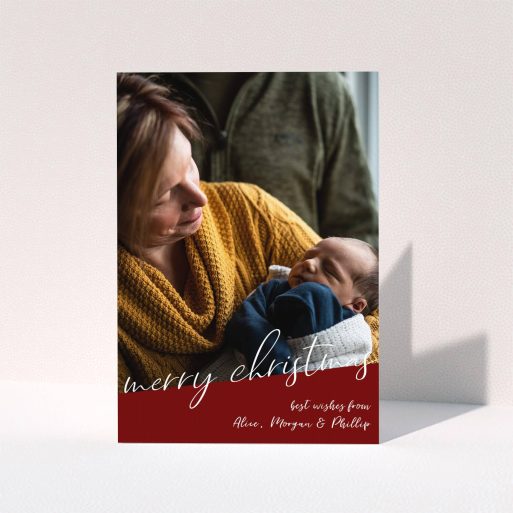 A personalised christmas card design called "Ski Slope". It is an A6 card in a portrait orientation. It is a photographic personalised christmas card with room for 1 photo. "Ski Slope" is available as a folded card, with tones of burgundy and white.