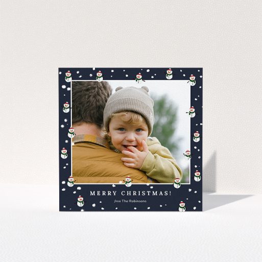 A personalised christmas card template titled "Snowmen and Snow". It is a square (148mm x 148mm) card in a square orientation. It is a photographic personalised christmas card with room for 1 photo. "Snowmen and Snow" is available as a folded card, with tones of navy blue, red and white.