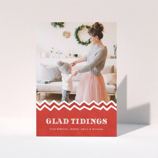 A personalised christmas card named "Tidal Tidings". It is an A5 card in a portrait orientation. It is a photographic personalised christmas card with room for 1 photo. "Tidal Tidings" is available as a folded card, with tones of red and white.