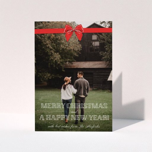 A personalised christmas card called "Under the Tree". It is an A5 card in a portrait orientation. It is a photographic personalised christmas card with room for 1 photo. "Under the Tree" is available as a folded card, with mainly red colouring.