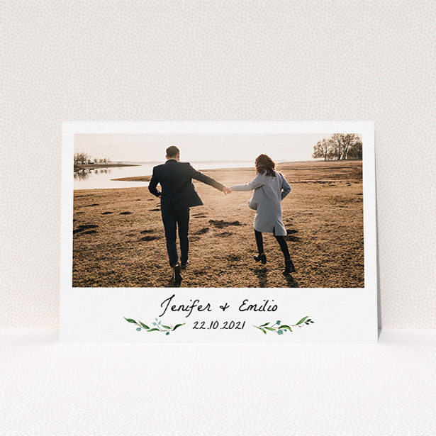 A personalised wedding invitation template titled "Floral Fix". It is an A5 invite in a landscape orientation. It is a photographic personalised wedding invitation with room for 1 photo. "Floral Fix" is available as a flat invite, with tones of white and light green.