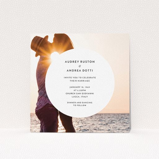 A personalised wedding invitation design titled "Surrounded". It is a square (148mm x 148mm) invite in a square orientation. It is a photographic personalised wedding invitation with room for 1 photo. "Surrounded" is available as a flat invite, with mainly white colouring.