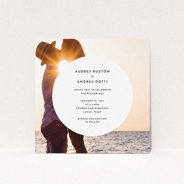 A personalised wedding invitation design titled "Surrounded". It is a square (148mm x 148mm) invite in a square orientation. It is a photographic personalised wedding invitation with room for 1 photo. "Surrounded" is available as a flat invite, with mainly white colouring.