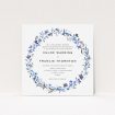 A personalised wedding invite design titled "Blue Floral Wreath". It is a square (148mm x 148mm) invite in a square orientation. "Blue Floral Wreath" is available as a flat invite, with tones of light blue, purple and grey.