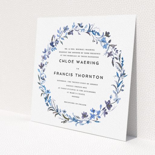 A personalised wedding invite design titled 'Blue Floral Wreath'. It is a square (148mm x 148mm) invite in a square orientation. 'Blue Floral Wreath' is available as a flat invite, with tones of light blue, purple and grey.