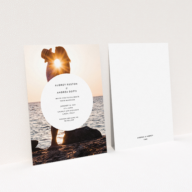 A personalised wedding invite design titled "Surrounded". It is an A5 invite in a portrait orientation. It is a photographic personalised wedding invite with room for 1 photo. "Surrounded" is available as a flat invite, with mainly white colouring.