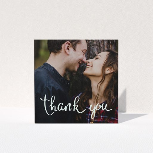 A photo wedding thank you card named "Curly thank you". It is a square (148mm x 148mm) card in a square orientation. It is a photographic photo wedding thank you card with room for 1 photo. "Curly thank you" is available as a folded card, with mainly white colouring.
