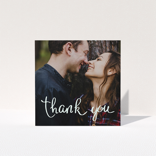 A photo wedding thank you card named "Curly thank you". It is a square (148mm x 148mm) card in a square orientation. It is a photographic photo wedding thank you card with room for 1 photo. "Curly thank you" is available as a folded card, with mainly white colouring.