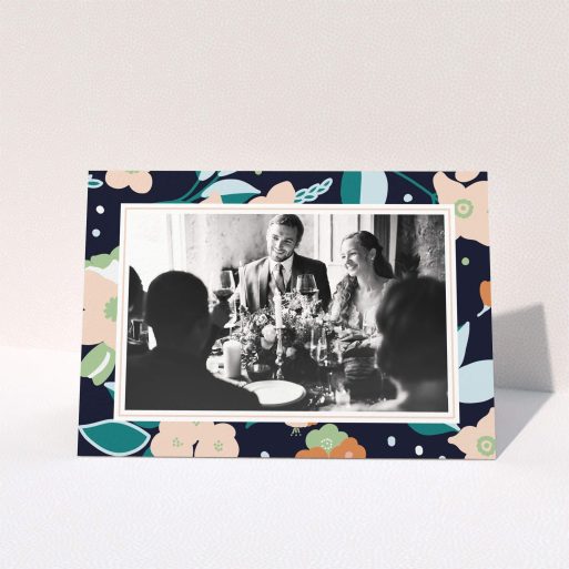 A photo wedding thank you card template titled "Midnight Garden Photo Frame". It is an A6 card in a landscape orientation. It is a photographic photo wedding thank you card with room for 1 photo. "Midnight Garden Photo Frame" is available as a folded card, with tones of navy blue, pink and orange.
