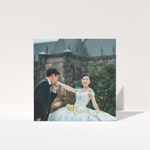 A photo wedding thank you card template titled "Thank you with a heart". It is a square (148mm x 148mm) card in a square orientation. It is a photographic photo wedding thank you card with room for 1 photo. "Thank you with a heart" is available as a folded card, with mainly gold colouring.