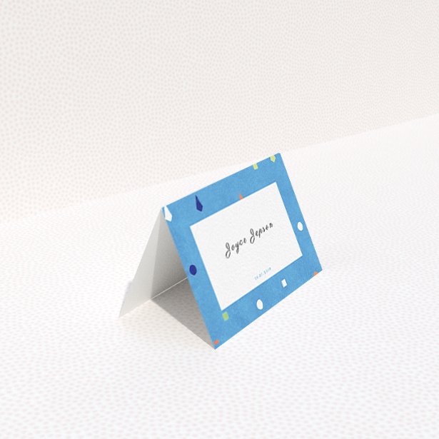 A place setting card named "Capri". It is an 85 x 55mm card in a landscape orientation. "Capri" is available as a folded card, with tones of light blue and orange.