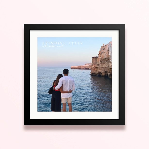 Framed and mounted photo print of a couple by the sea with cliffs in the background and text overlay.