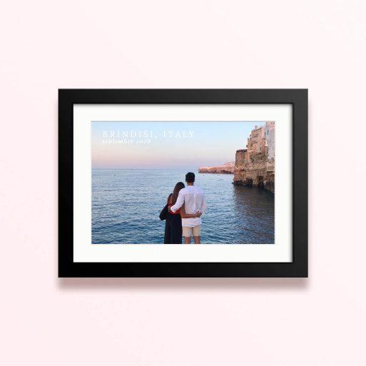Framed and mounted photo print of a couple by the sea with cliffs in the background and text overlay.
