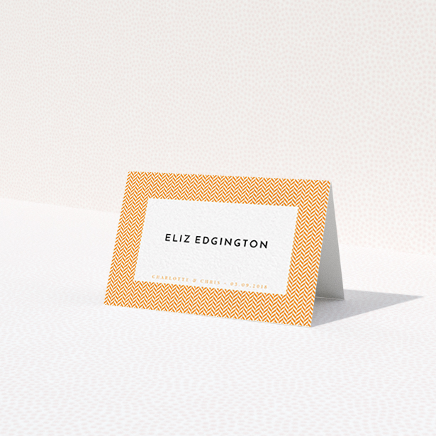 A table place card design titled 'Orange Houndstooth'. It is an 85 x 55mm card in a landscape orientation. 'Orange Houndstooth' is available as a folded card, with tones of orange and white.