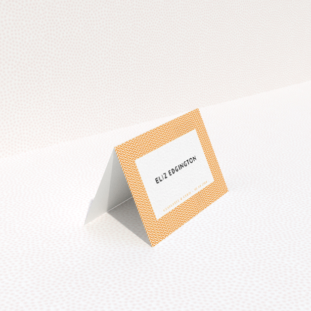 A table place card design titled "Orange Houndstooth". It is an 85 x 55mm card in a landscape orientation. "Orange Houndstooth" is available as a folded card, with tones of orange and white.