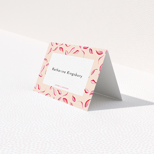 A table place card design named "Petal avalanche". It is an 85 x 55mm card in a landscape orientation. "Petal avalanche" is available as a folded card, with tones of pink, red and white.