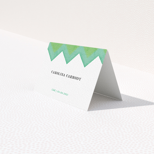 A table place card named "Vibrant Peaks". It is an 85 x 55mm card in a landscape orientation. "Vibrant Peaks" is available as a folded card, with tones of green and white.