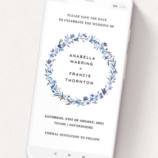 A text message save the date design titled 'Blue Floral Wreath'. It is a smartphone screen sized save the date in a portrait orientation. 'Blue Floral Wreath' is available as a flat save the date, with tones of light blue, purple and grey.