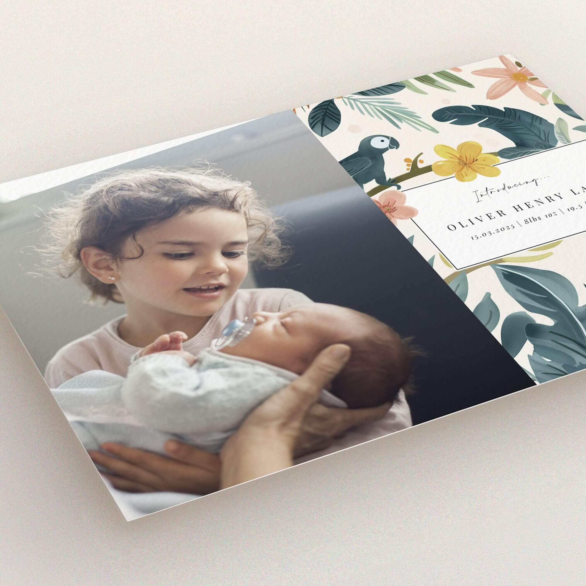 Floral illustrated birth announcement card design with one photo of a child holding a baby.